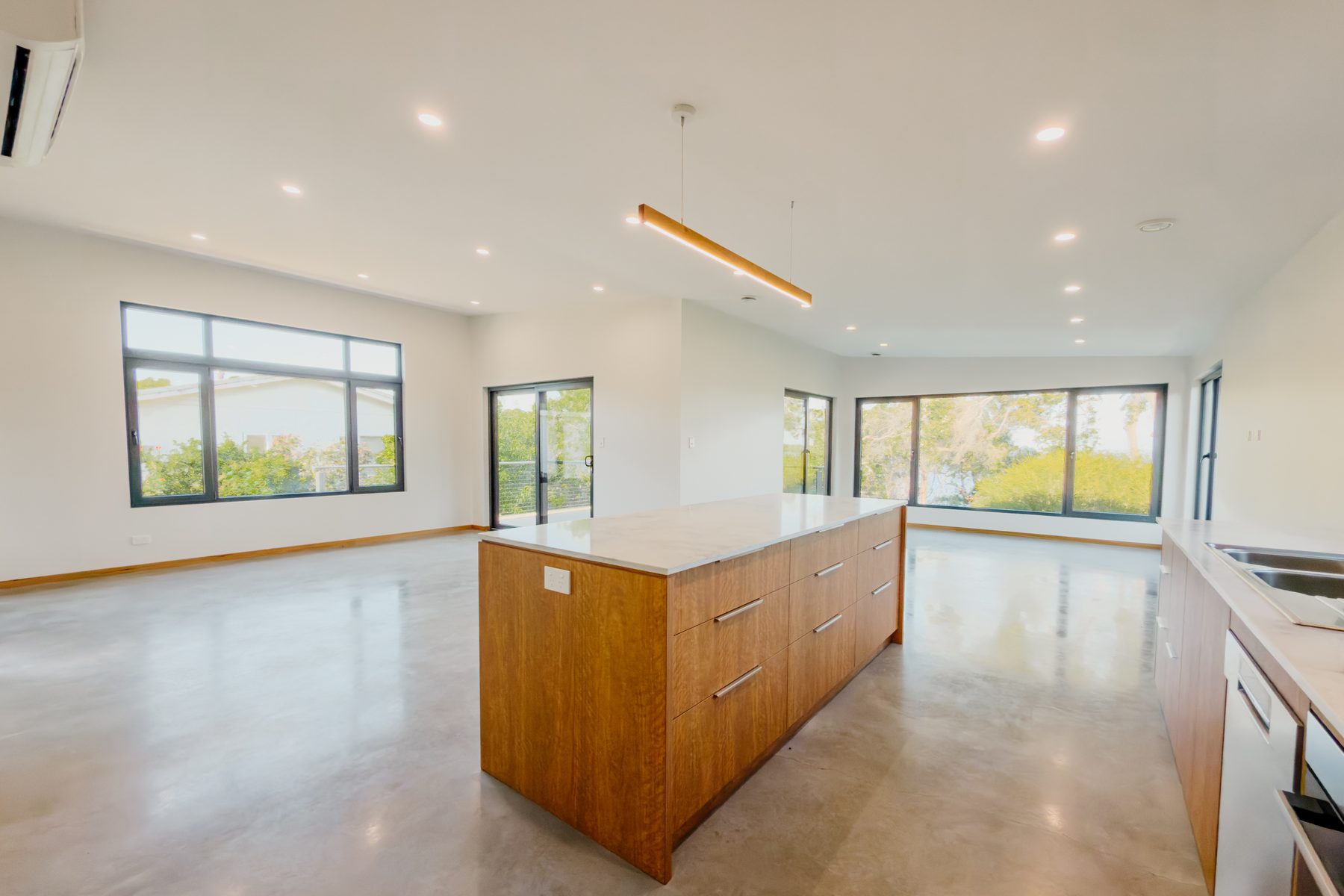 Open-plan living, kitchen and polished concrete floor in a completed home